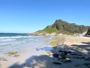 a beach with people walking on the sand and the ocean at La Casa de los Libros in Muros de Nalón +37 photos