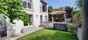 a small backyard with a hot tub and an umbrella at Villa SPA Hyères 6 personnes au calme in Hyères