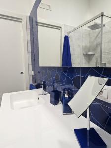 bagno con lavandino bianco e piastrelle blu di Holiday home Endless Summer - Amalfi Coast a Maiori