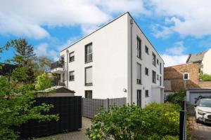 a white house with a black fence at Jungle Deluxe Suite - Parken Balkon Jumanji TV in Offenbach