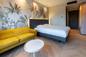 a hotel room with a bed and a couch at MyHotel Meppel in Meppel