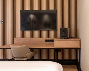 a bedroom with a desk with a television and a chair at MyHotel Meppel in Meppel
