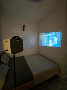 a bedroom with a bed with a tv on the wall at Homestay 1999 in Tân Tạo
