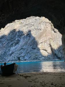 a boat sitting on the beach next to a cave at Riverside Komani Lake in Koman