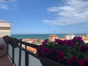 a balcony with purple flowers and the ocean at A Casa Così B&b in Marzocca di Senigallia