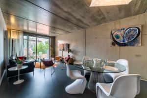 a dining room with a glass table and white chairs at L'INOX in Toulouse