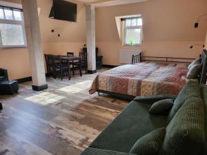 - une chambre avec un lit, un canapé et une table dans l'établissement Hotel & Ferienpark Fleether Mühle, à Mirow