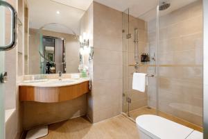 La salle de bains est pourvue d'un lavabo et d'une douche. dans l'établissement GuangDong Hotel Shanghai, à Shanghai