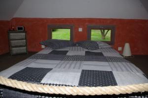 1 cama grande en un dormitorio con 2 ventanas en la bergerie, en Laubressel