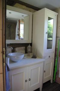 Un baño con un lavabo blanco y un espejo. en la bergerie, en Laubressel