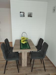 a dining room table with four chairs and a basket of fruit at Haus Abendrot in Dornbirn