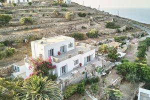 a white house on a hill next to the ocean at BELLAVISTA HOUSE in Sifnos