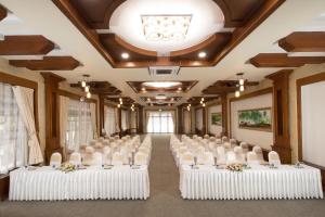 a banquet hall with white tables and chairs and a ceiling at Phuong Nam Resort in Thuan An