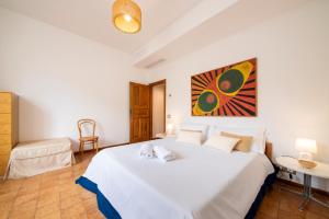 a bedroom with a large white bed and a table at Il Lauro Luxury Villa in Ischia