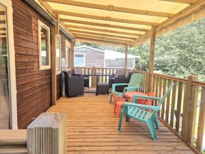 a wooden deck with chairs and a table at Mobilhome Labenne Océan in Labenne
