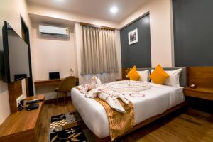 Carry Inn Hotel Indore في إندوري: غرفة في الفندق مع سرير ومكتب