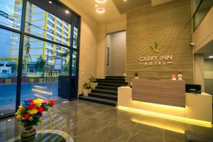 Carry Inn Hotel Indore في إندوري: لوبي فندق مع إناء من الزهور