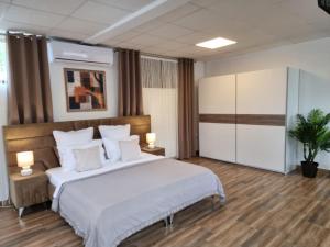 um quarto com uma cama grande com lençóis brancos e almofadas em Studio Aurora Blue em Eforie Sud