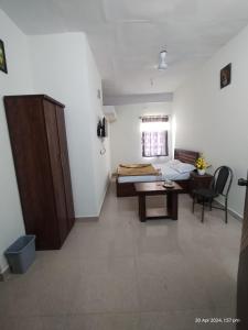 a room with a bed and a desk and a table at GM Comforts -LODGE-CL-7 in Bangalore