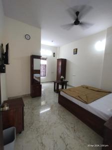 a bedroom with a bed and a ceiling fan at GM Comforts -LODGE-CL-7 in Bangalore