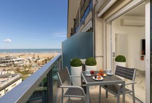 リミニにあるArtis Appartamentoのビーチを望むバルコニー(テーブル、椅子付)