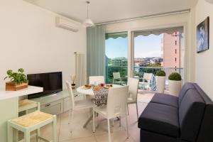 a living room with a table and a couch and a television at Artis Appartamento in Rimini