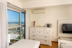 a bedroom with a bed and a tv and a window at Artis Appartamento in Rimini