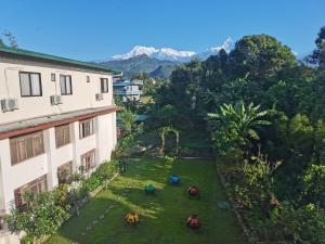 uitzicht op een tuin tussen twee gebouwen bij Dragon Hotel in Pokhara