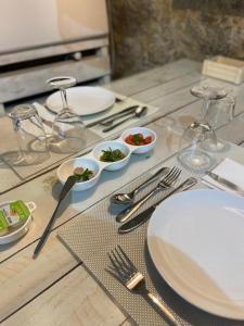a wooden table with white plates and silverware on it at Casas da Quinta da Cancela in Balugães
