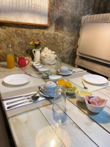 una mesa con platos y tazones de comida. en Casas da Quinta da Cancela, en Balugães