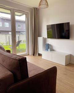 salon z kanapą i telewizorem z płaskim ekranem w obiekcie BlueHouse Apartment Warsaw w Warszawie