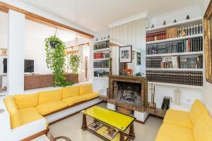 sala de estar con sofá amarillo y chimenea en Casa El Maizal, en Marbella