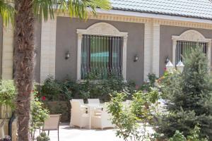 a house with a table and chairs in a garden at Museum Guest House-Muzey Ailəvi Qonaq Evi in Sheki