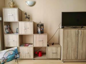 a living room with a tv on a wooden entertainment center at Maison de charme - proche toutes commodités in Marseillan