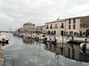 a group of boats docked in a canal with buildings at Maison de charme - proche toutes commodités in Marseillan