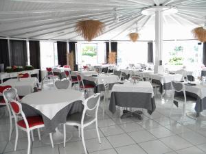 a restaurant with white tables and chairs and windows at HOTEL GENOVA in Scalea