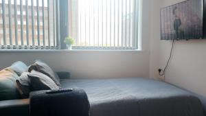 a bedroom with a bed and a large window at Stunning one bedroom near Old Trafford Stadium in Manchester