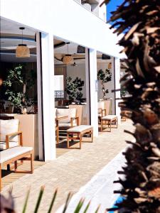 una fila de sillas y mesas en un patio en Sveltos Hotel, en Lárnaca