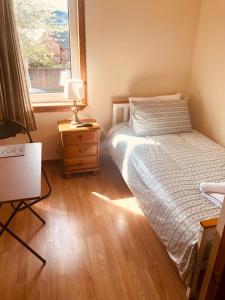 a small bedroom with a bed and a window at Inverthorn House in Inverness