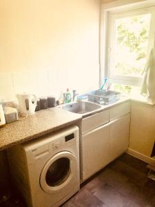 a kitchen with a sink and a washing machine at Inverthorn House in Inverness