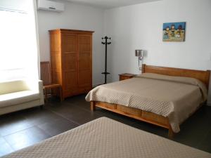 a bedroom with a bed and a dresser and a sink at HOTEL GENOVA in Scalea