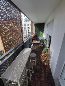 a balcony with a bench and chairs on a building at cosy appartement proche de la Défense in Bezons