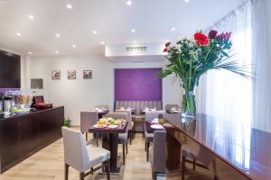 un comedor con una mesa con un jarrón de flores en Hotel Jenner, en París