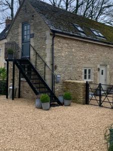 a brick house with a staircase in front of it at The Barn in South Cerney