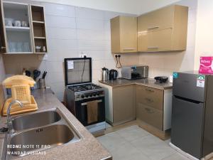 a kitchen with a sink and a stove at Furnished room with swimming pool near shopping mall in Mombasa