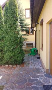 a green bench next to a building with a tree at Hostel Łąkowa 69 in Suwałki