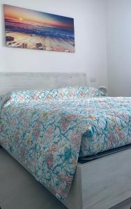 a bed with a colorful comforter in a room at Residenza Acquaverde in Bibione Pineda +35 photos