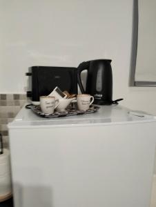 un mostrador con tres tazas y una cafetera en Casa rural Daisamar, en Teguitar