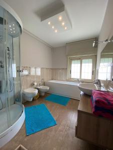 a bathroom with two sinks and a tub and two toilets at Tyttyhouse in Giardini Naxos