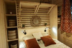 a room with a bed and a mirror and shelves at Camping Colombres in Colombres